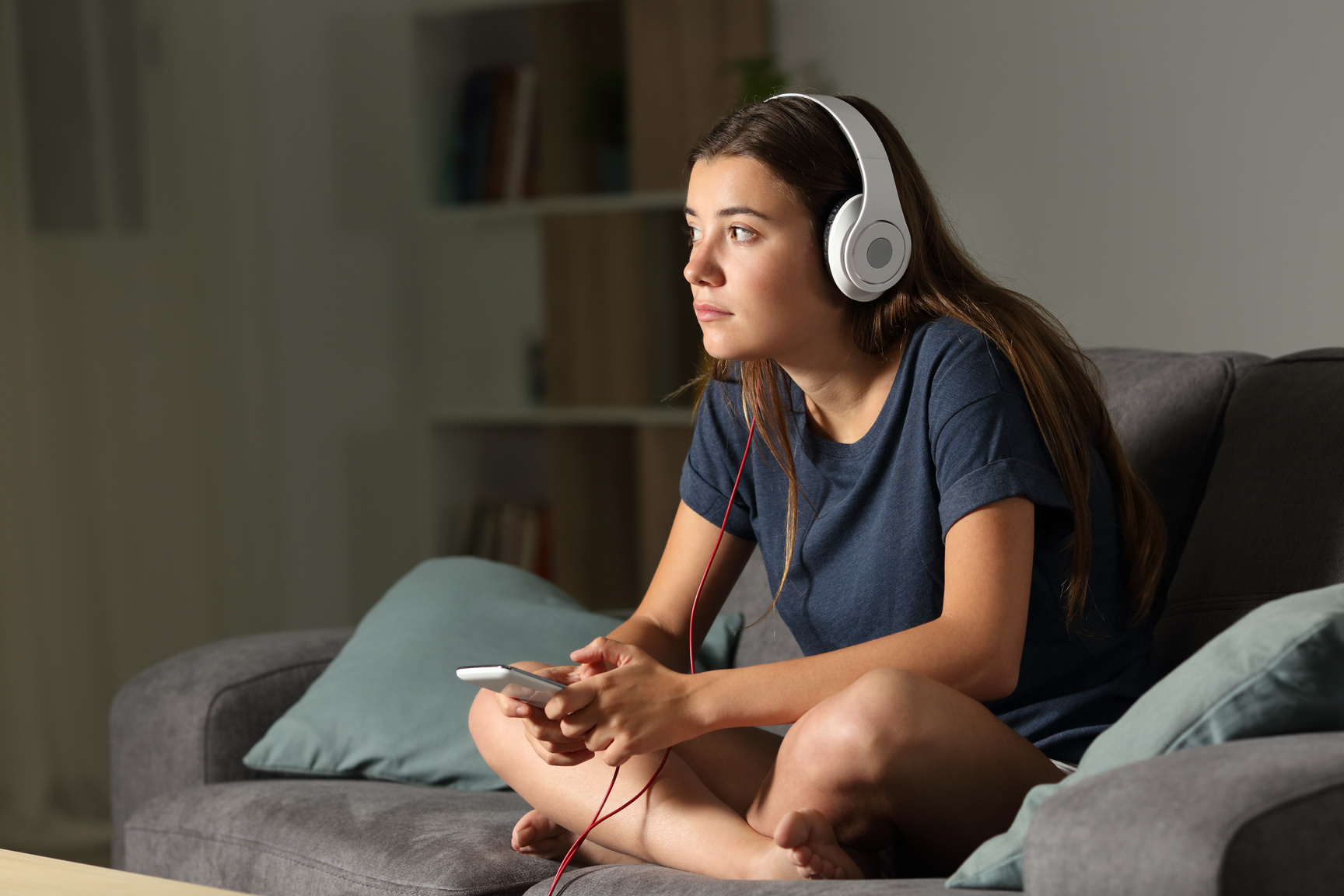 Pensive teen listening to music in the night